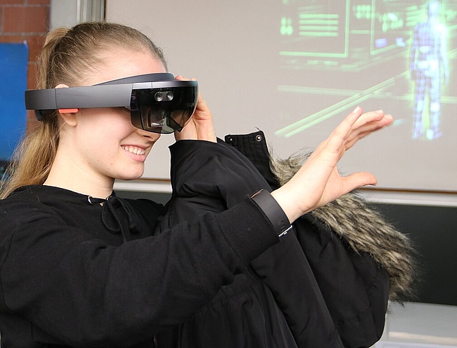 Eine Schülerin setzte die Hololens auf, mit der interaktive 3D-Projektionen in der direkten Umgebung dargestellt werden können. (Bild: mim)
