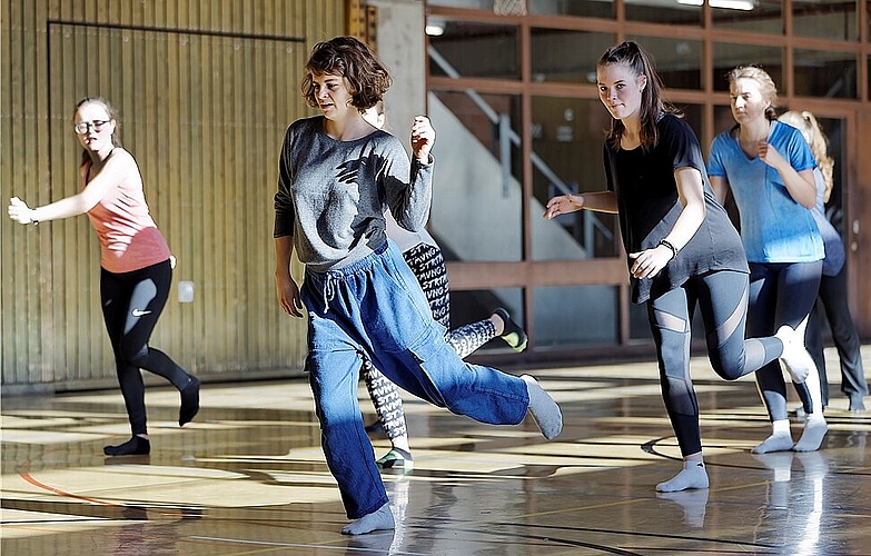 Tänzerin, Choreografin und Tanzvermittlerin Clea Onori (M.) leitet die Gruppe der Kantischülerinnen an. (Bild: André Albrecht)
