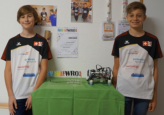 Jakob Hechler (l.) und Nicola Alessandrelli mit ihrem eigens gebauten und programmierten Roboter und dem Gewinner-Pokal der Vorausscheidung, mit dem sie sich für die World Robot Olympiad in Thailand qualifizierten. (Bild: Franz Beidler)