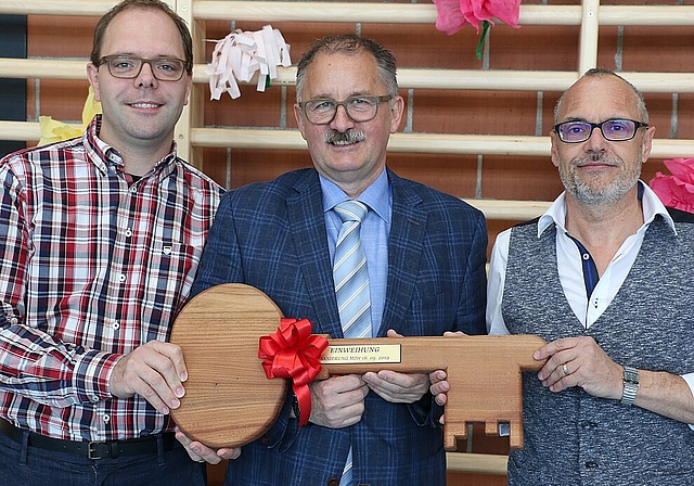 Bevor die Besucherinnen und Besucher die neue Halle erkunden konnten, überreichte der Präsident der Arbeitsgruppe Markus Huber (r.), dem Gemeindepräsidenten Peter Frei (m.) sowie Christian Hug (l.), Gemeinderat Ressort Bauwesen, symbolisch den Sch