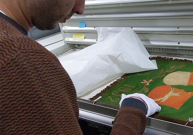 Ein Zivilschützer ordnet eine alte Fahne im Kulturgüterschütz-Raum unter dem Oltner Werkhof. (Bild: ZVG)
