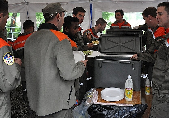 Die Küchenmannschaft (rechts) schöpft das Mittagessen für die Zivilschützer. (Bild: ZVG)