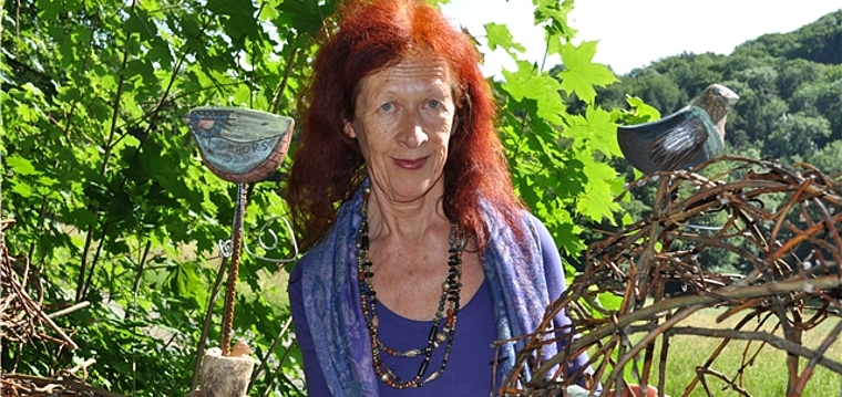 Die Künstlerin Lotti Walti inmitten ihrer pastellfarbenen Vögel im Säliwald. mim)
