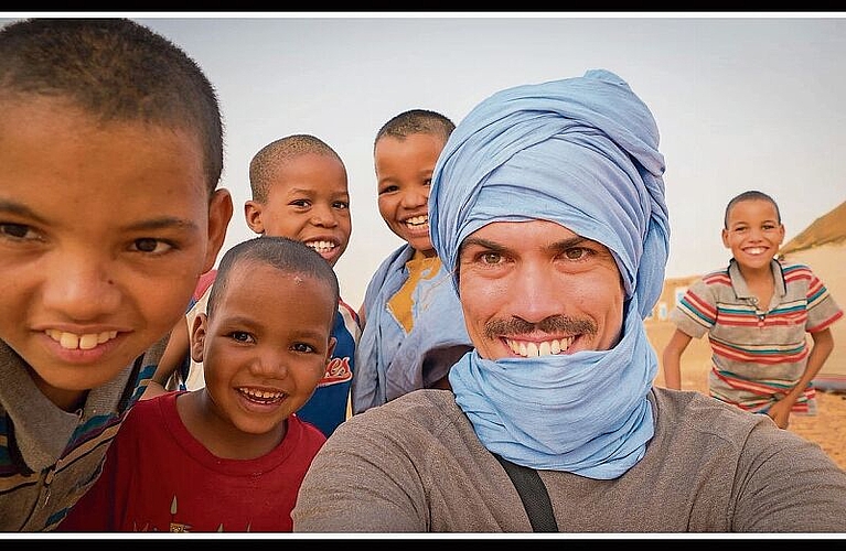 Gelöste Stimmung: Raphael Fischer lässt sich bei einer seiner vielen Reisen mit Kindern in Mauretanien fotografieren. (Bilder: ZVG)
