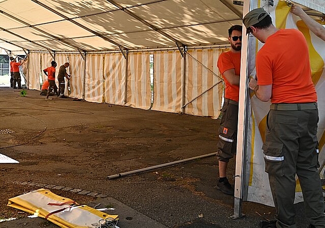 Die Zivilschützer helfen beim Aufbau eines Zelts. (Bild: ZVG)