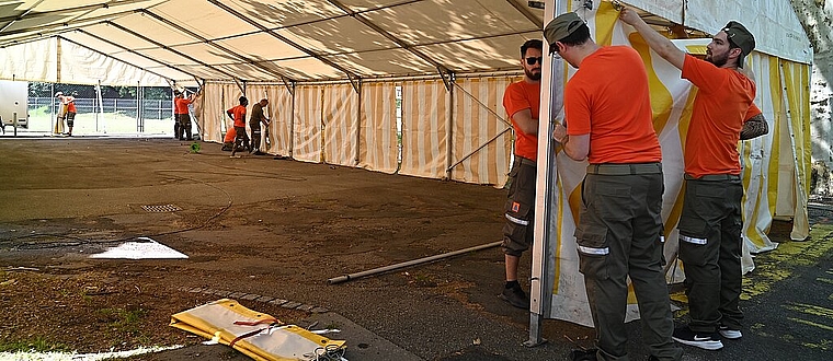 Die Zivilschützer helfen beim Aufbau eines Zelts. (Bild: ZVG)