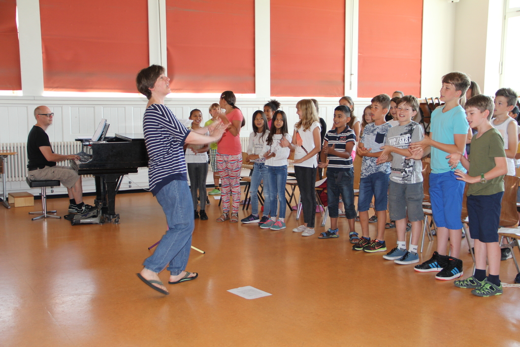 Chor-Aufwärmübungen im Bifang-Schulhaus unter der Leitung von Musikschul- und Chorleiterin Sandra Rupp Fischer und in Begleitung des Orchesterleiters Roman Wyss mit 30 Kindern. (Bild: mim)

