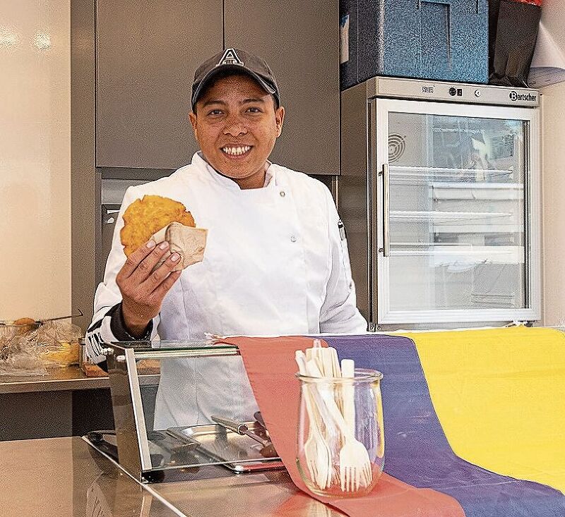 Efrain Igirio bereitet frische Arepas zu.
