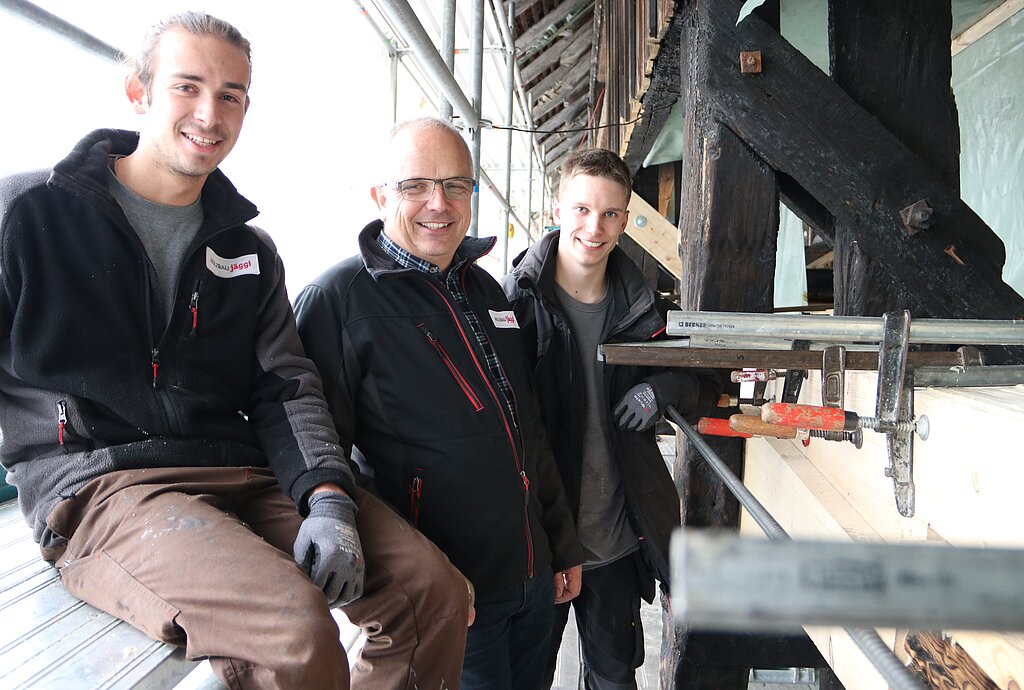 (v.l.) Zimmermann Nicolas Gilgen, Inhaber Jonas Bader und Lehrling Florian Pfister. Nicolas Gilgen zeigte bei der Verleimung von verschiedenen Brettern, die den ausgebrannten Balken wieder verschliessen, besondere Präzisionsarbeit. (Bild: mim)