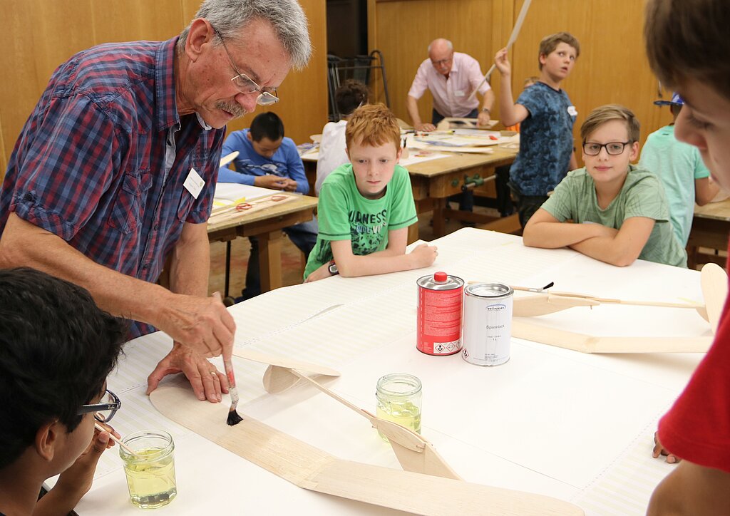 Toni Käser sowie fünf weitere Helfer von der Modellfluggruppe Wangen bauten zusammen mit den Kindern hölzerne Flugzeuge aus einem Bausatz zusammen und liessen sie fliegen. (Bild: A. Strähl)
